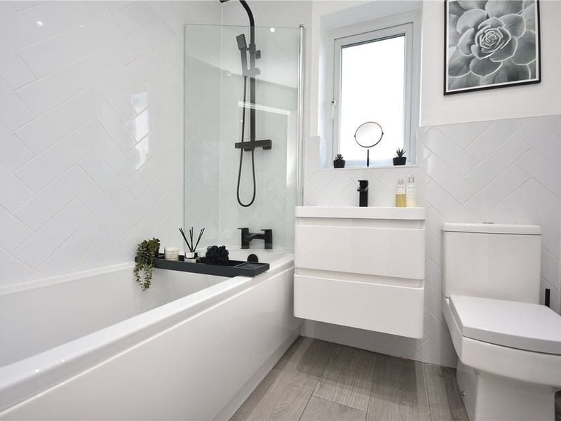 The contemporary house bathroom has a modern three-piece suite in white.