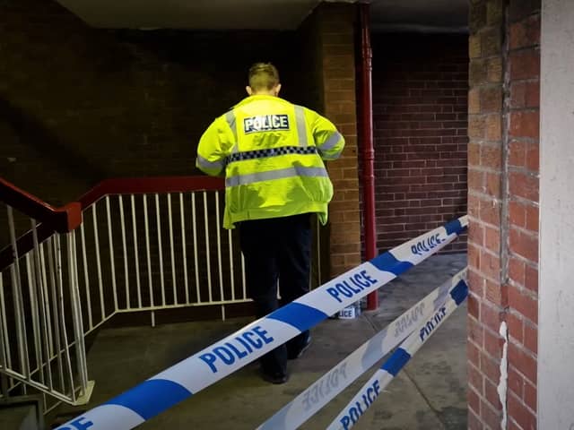 Forensic specialists examined  a stairwell at Cliff Street flats after a masked gang stabbed two men.