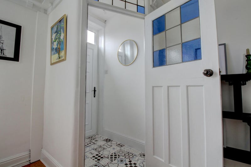 The entrance vestibule with stained glass door welcomes you into the home.