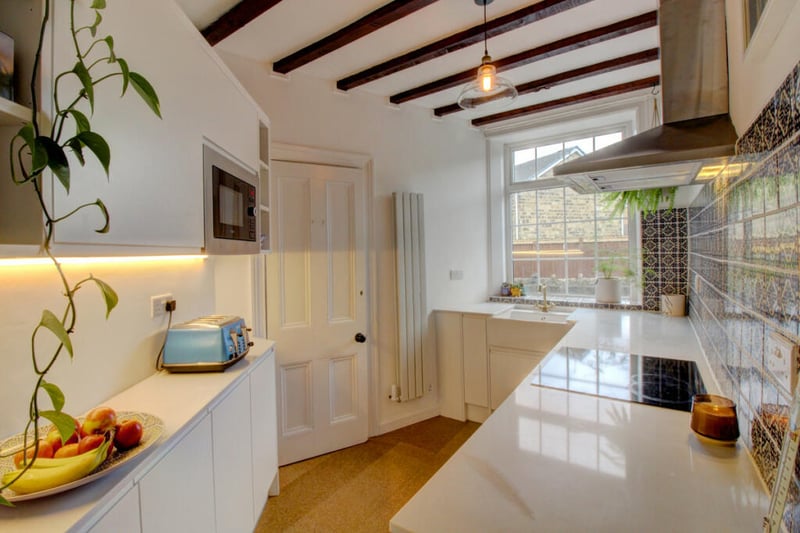 The recently renovated kitchen is modern et retains characterful features like exposed ceiling beams.