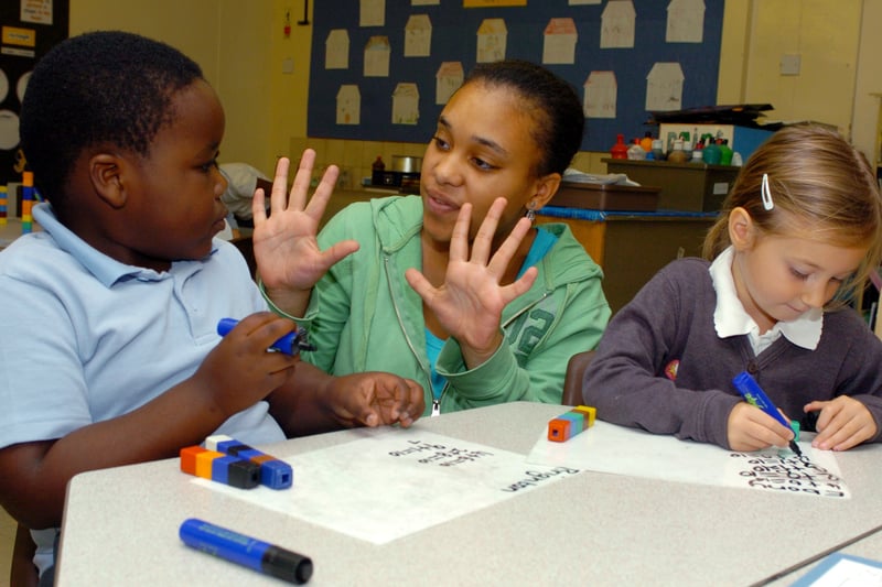 Teaching assistant Monair Hyman at Seacroft Grange Primary School with Year 1 pupils Brighton Mhizha and Eboni Clough. Pictured in September 2007.