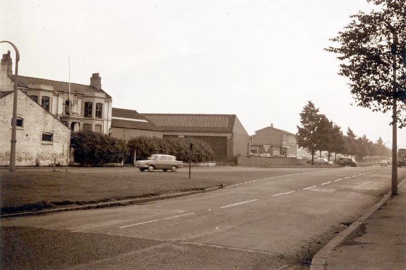 Ring Road Beeston by the junction with Elland Road. On the left is Crow Nest House, part of the Crow Nest Works, formerly the sausage skin factory of Kraft & Hornings but around the time of the photo it had been used by a transport firm. The photo taken around the late 1950s, shows the building in poor condition, with the ground floor windows boarded up and broken panes at the upper storey level. A Ford Anglia car can be seen.