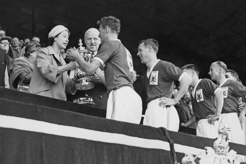 Queen Elizabeth II presents the FA Cup trophy to Nottingham Forest Football Club team captain Jack Burkitt. The Reds defeated Luton 2-1 in the 1959 final.