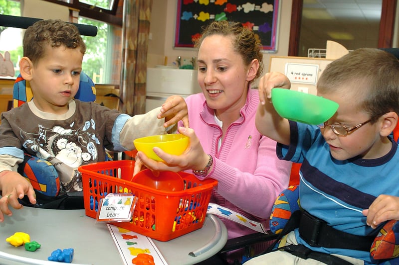 Young Cerebral Palsy sufferer Jordan Bailey plays with his friend Harry Pickering and nursery assistant Helen Dawson at the Seacroft Children's Centre in May 2005.