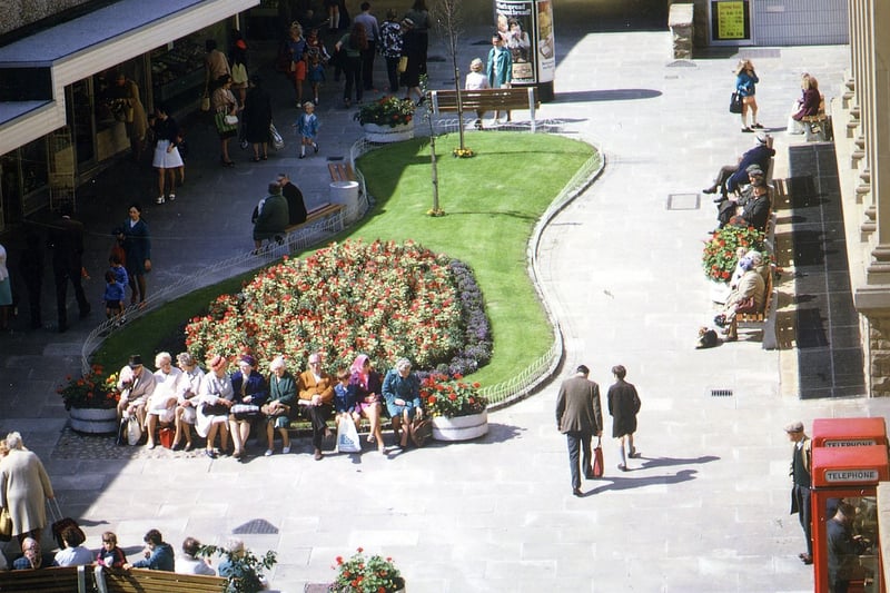 Windsor Court shopping precinct off Queen Street, by the side of the Town Hall. The area is busy with shoppers and people taking a rest on the seats around the flower beds. Pictured in August 1973.