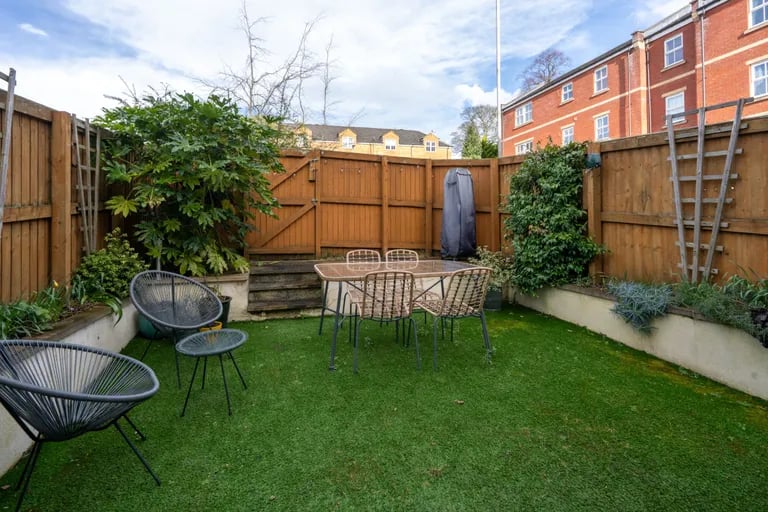 The landscaped rear garden features Astroturf and built-in planters.