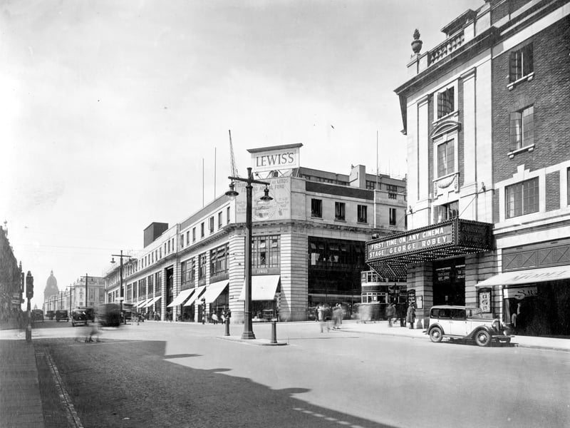Looking across junction with New Briggate, Odeon Cinema on right in July 1934. Lewis's store, then one of the largest to be built in the North of England. Work began in 1930, it was opened in September 1932 but was not completed until 1939, when three more floors had been added. On front of store is an appeal for funds for Leeds General Infirmary. Leeds Town Hall can be seen on the left.