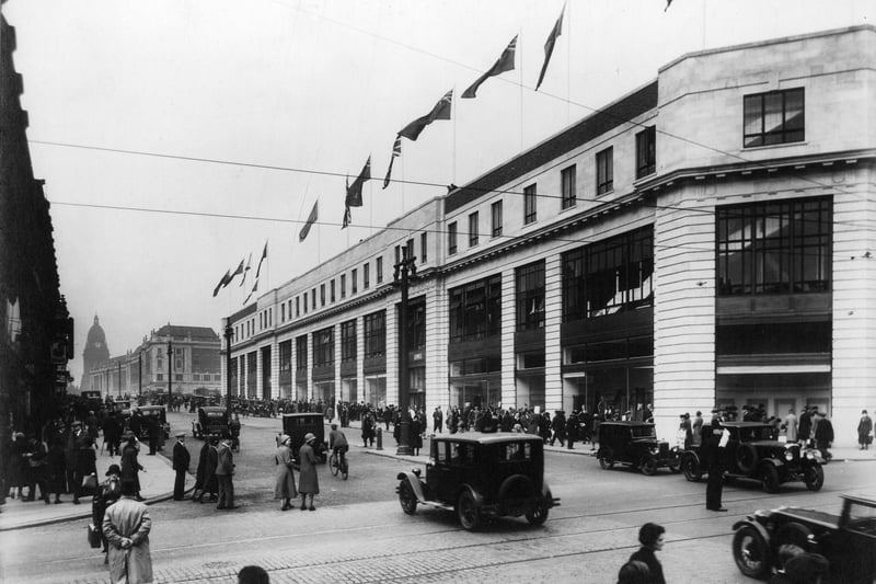 The Headrow looking west from the junction with Briggate. The main focus is Lewis's department store, possibly just opened judging by the number of people on the street outside and queueing to get in, and by the line of flags displayed along the top of the building. The store was officially opened on 17th September 1932 but it was not until 1938 that it was fully completed with 3 more floors added.