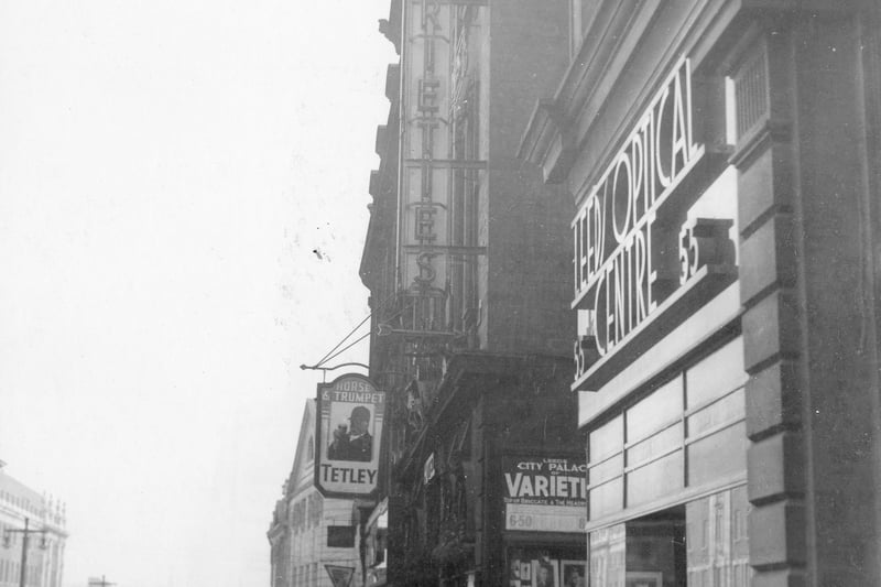September 1937 and left is Lewis's store. Then number 51 the Horse and Trumpet public house. Number 53 is the Leeds optical centre with bespectacled man in doorway. Leeds City Varieties lying between the two. Reputedly the oldest surviving theatre in Britain. Its roots can be traced back to the singing room of the White Swan coaching inn. It was named the City Varieties in 1894. From 1953 it was the home of producer Barney Colehans' 'Good Old Days' television programme. In 1987, the theatre was bought by Leeds City Council. 