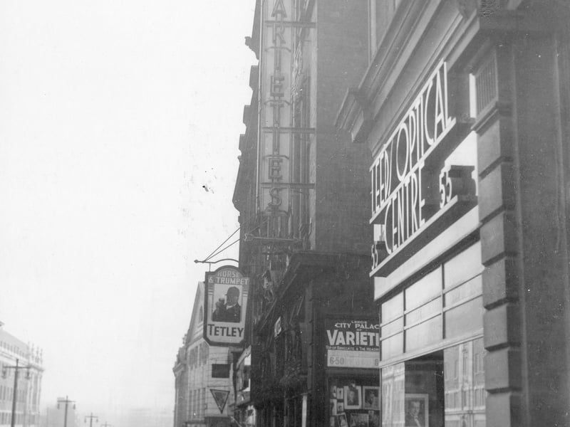 September 1937 and left is Lewis's store. Then number 51 the Horse and Trumpet public house. Number 53 is the Leeds optical centre with bespectacled man in doorway. Leeds City Varieties lying between the two. Reputedly the oldest surviving theatre in Britain. Its roots can be traced back to the singing room of the White Swan coaching inn. It was named the City Varieties in 1894. From 1953 it was the home of producer Barney Colehans' 'Good Old Days' television programme. In 1987, the theatre was bought by Leeds City Council. 