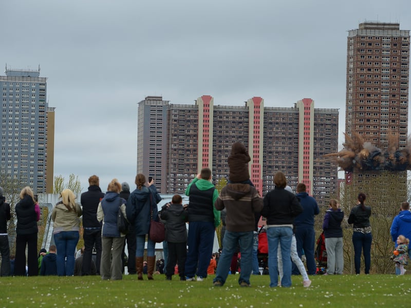 Members of the public look on as the thirty story tower block at Birnie Court is demolished on May 5, 2013 in Glasgow.