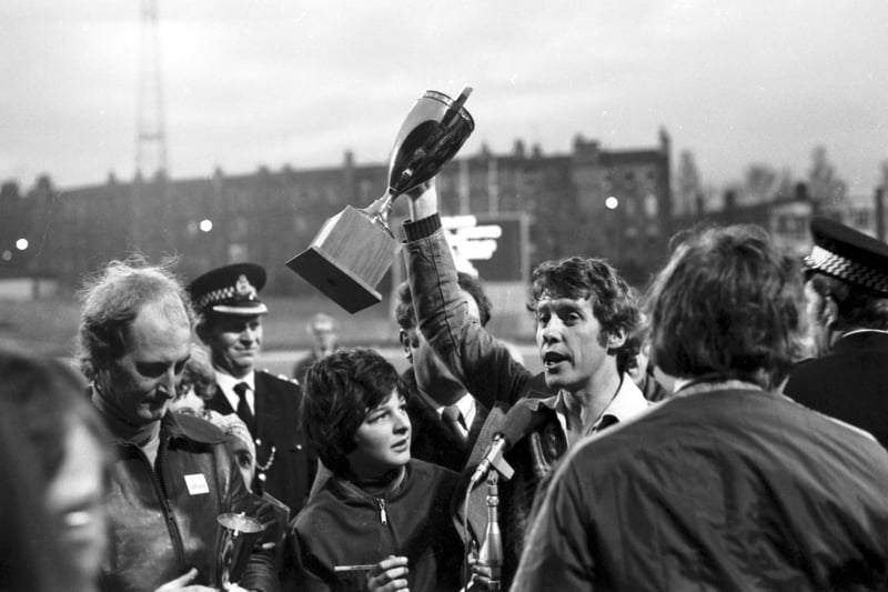 Actor Michael Crawford holds up the trophy for the Evening News Charity Walk in December 1974.