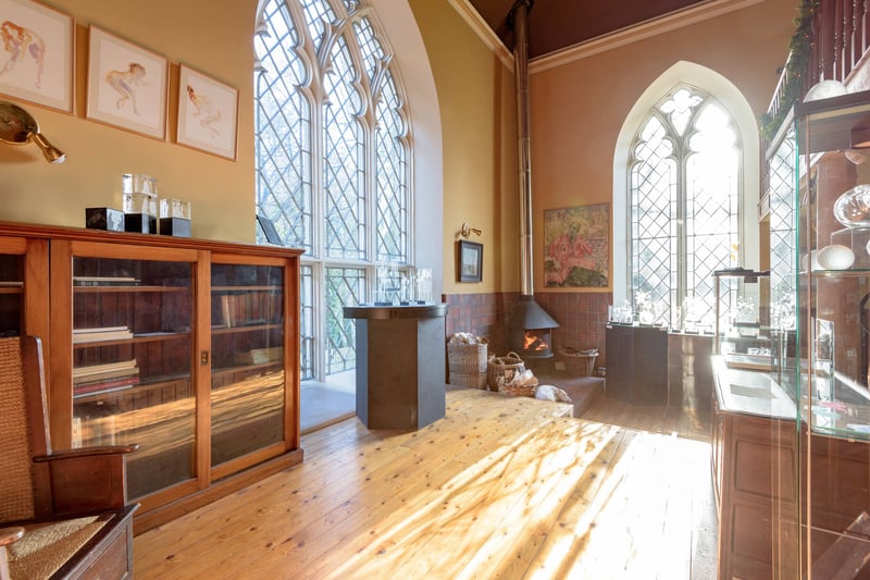 The elegant sitting room with beautiful stained glass windows and an impressive wood burning stove.
