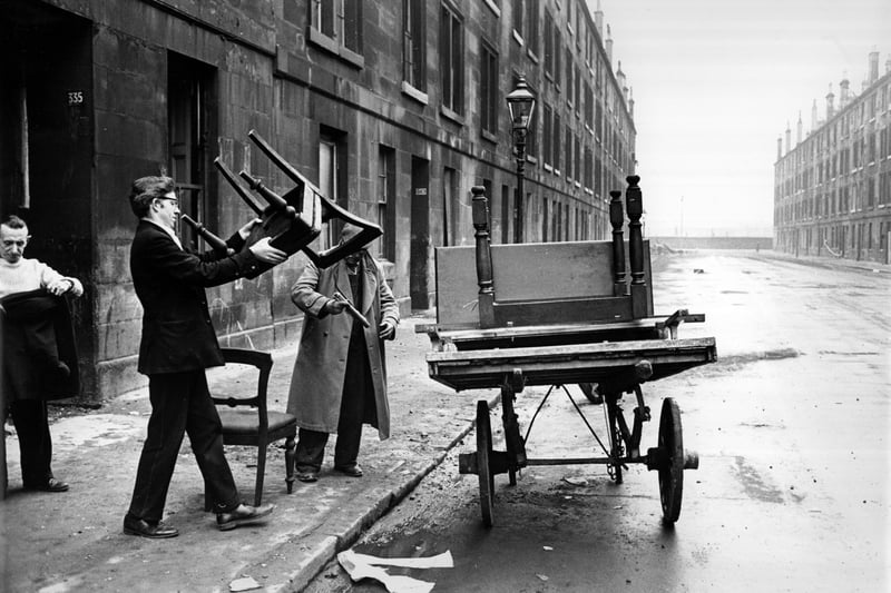 A man piling furniture onto a cart in a street of soon-to-be-demolished tenements in the Gorbals in 1960. 