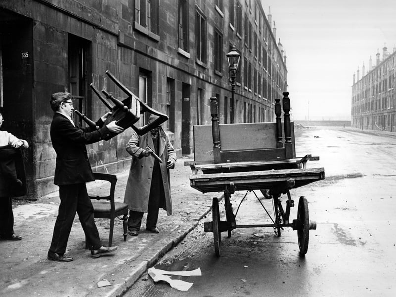 A man piling furniture onto a cart in a street of soon-to-be-demolished tenements in the Gorbals in 1960. 