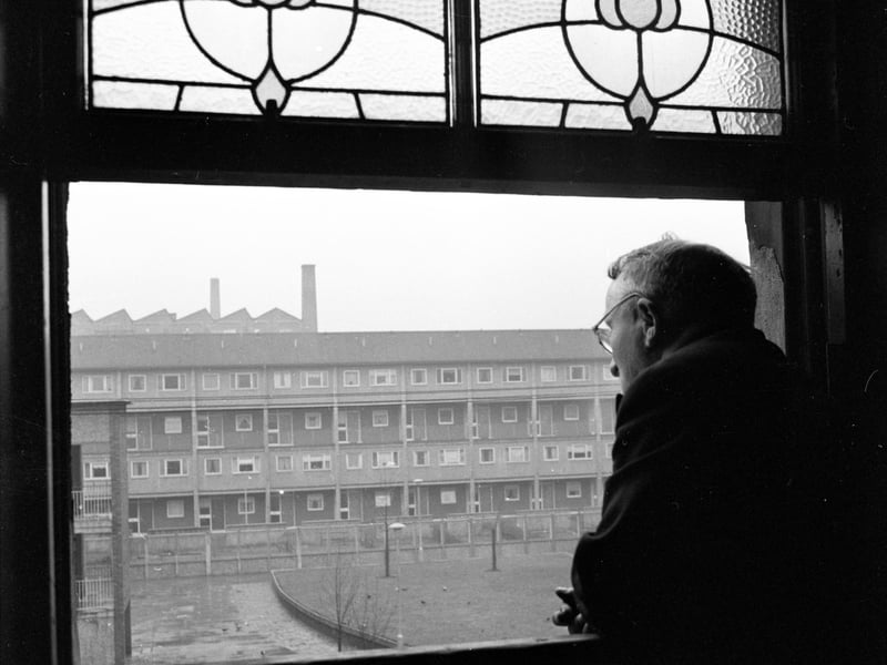 A resident of the Gorbals looking out of his window at a row of newly-built housing.