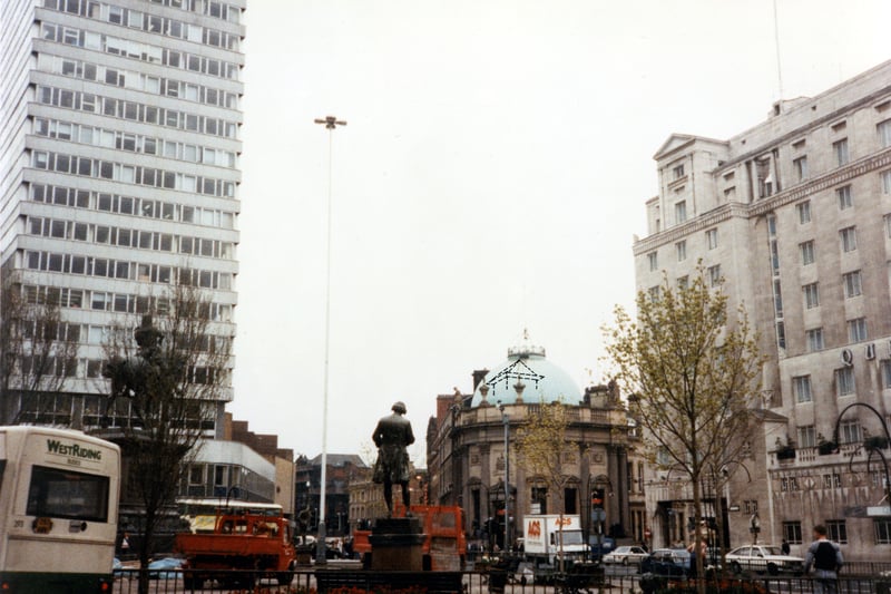 Looking east across City Square towards Boar Lane and Bishopgate Street in April 1990. The statues of Joseph Priestley and the Black Prince can be seen. The tall building on the left is Royal Exchange House; in the centre with the domed roof is the Observatory wine bar, formerly the Midland Bank. On the right is the Queen's Hotel.