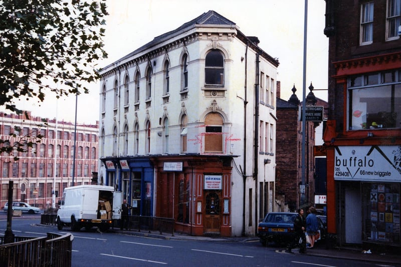 Shops on New Briggate pictured in November 1990. On the right is no. 66, Buffalo Menswear, then Star of Bengal, Tandoori Restaurant, and McGranes Musical Instruments. A van is parked outside McGranes. Merrion Place is between no. 66 and 68.