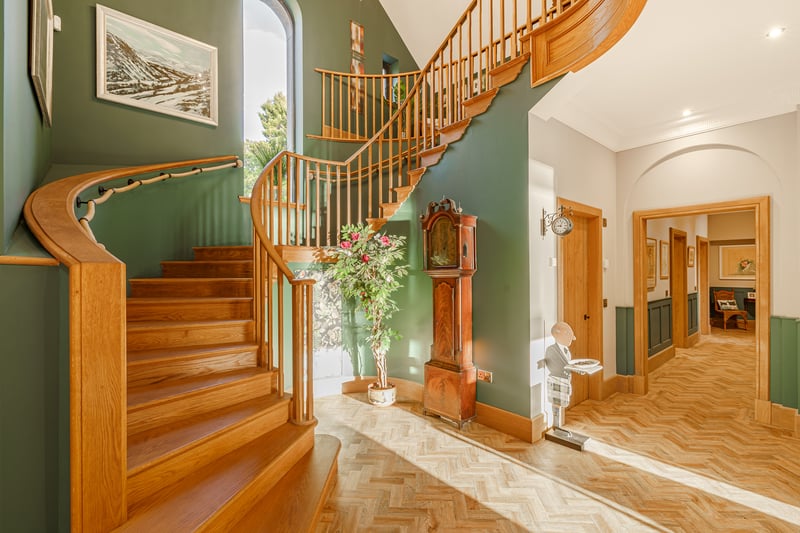 A welcoming reception hall
features a double-height ceiling and a sweeping handmade oak staircase,
which leads to the home’s galleried first-floor landing.