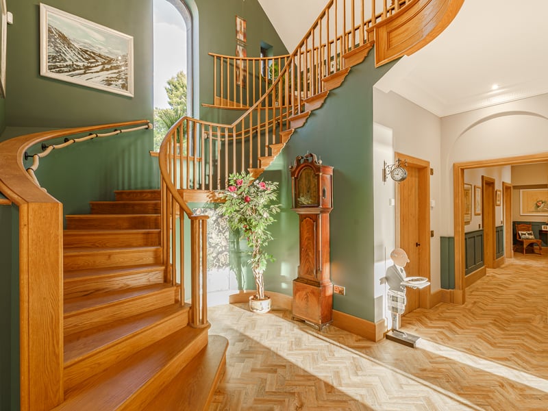 A welcoming reception hall
features a double-height ceiling and a sweeping handmade oak staircase,
which leads to the home’s galleried first-floor landing.