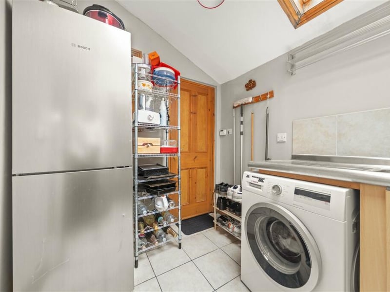 Behind the kitchen is a handy utility room with American style fridge freezer.