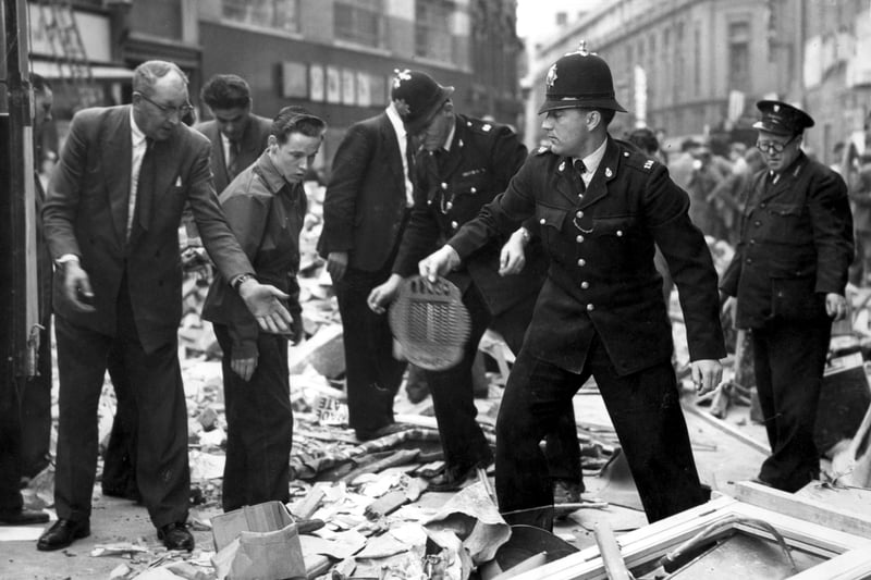 Police join in the grim task of sifting through the Redman's cafe ruins