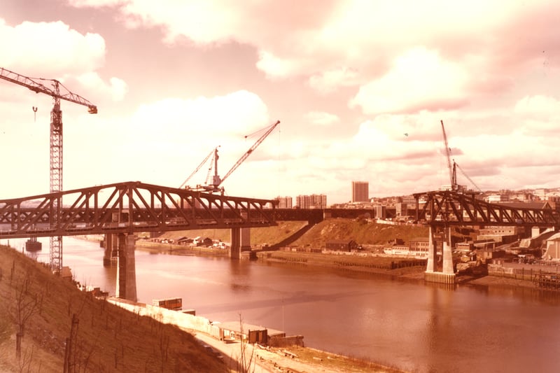 A 1978 photograph of the construction of the Queen Elizabeth II Bridge. The sections of the bridge on either side of the river are complete but the middle section is missing.