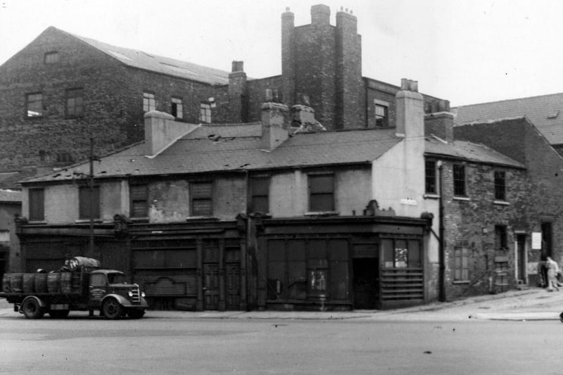 The junction of West Street with New Park Street and a disused two storey building with wood decoration around doors. An open truck with kegs or barrels is visible. Pictured in September 1949.