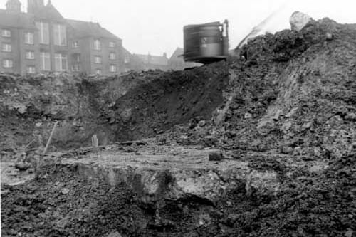Mud and rubble and some machinery where there is work on a static water basin foundation between Regent Street and Leylands Road, opposite Leeds College of Technology Department of Building, which can be seen in the top left corner. Pictured in January 1952. 
