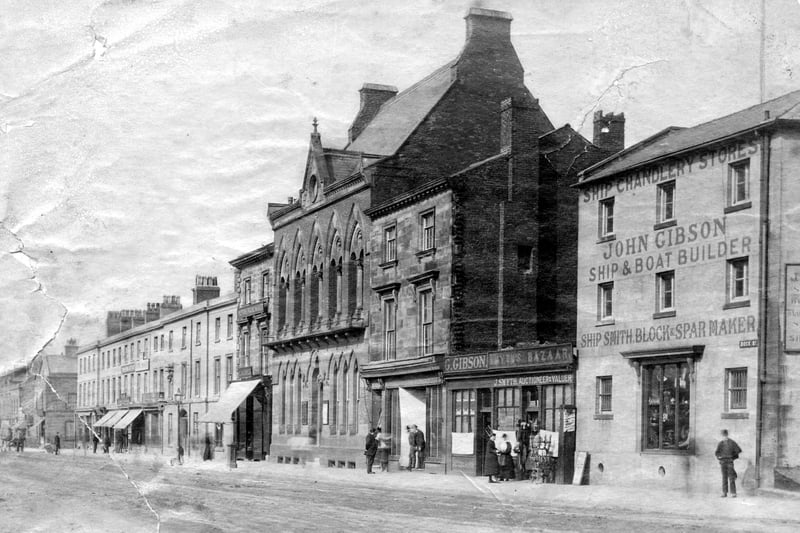 Dock Street in Fleetwood in the late 19th or early 20th century. Prominent buildings include John Gibson Ship and Boat Builder (on the right) and next door is J Smyth Auctioneer and Valuer. The Fielden building is also prominent