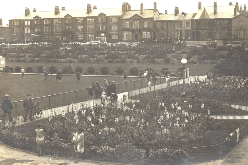 This summer scene depicts flower beds and the bowling greens in between the pier and the Marine Hall in the 1920s