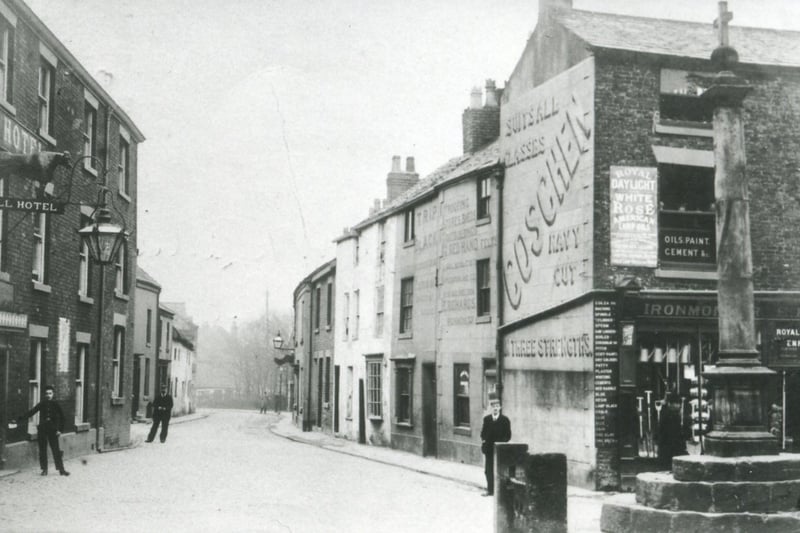 In 1904 the view down Blackpool Old Road from its junction with Poulton Market Place was very different than today. The old mill building further along on the left and the houses and shops on the right have all given way to road improvement and modern development. 
The Bull on the left and building on the right, which was then an ironmongers, advertising a brand of cigarettes which 'suits all classes' remain, along with  the stocks and the market cross