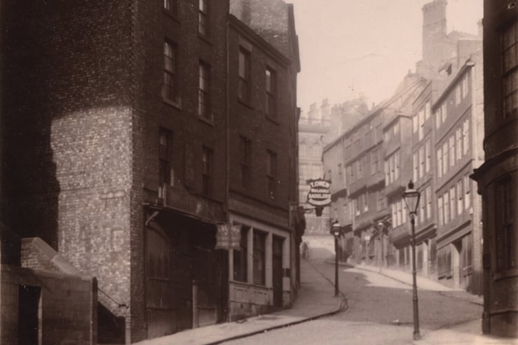 A view of the Side Newcastle upon Tyne taken in 1899. The photograph has been taken from the junction of Dean Street and the Side and is looking up the Side towards St. Nicholas Street. The buildings include the premises of 'T. Owen Saddlers Ironmonger'. Buildings on St. Nicholas Street can be seen in the background.