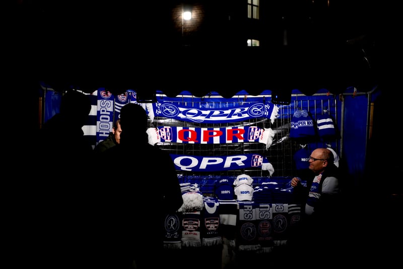 The blue and white of QPR illuminated at a nearby scarf stall.