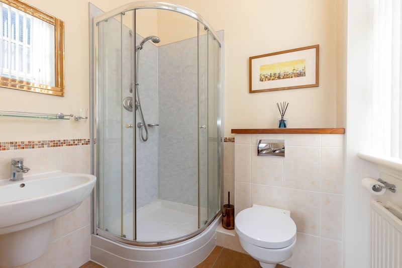 The principal bedroom's en-suite shower room with white two-piece suite comprising wash hand basin and WC. There is also a corner shower compartment with mixer shower.