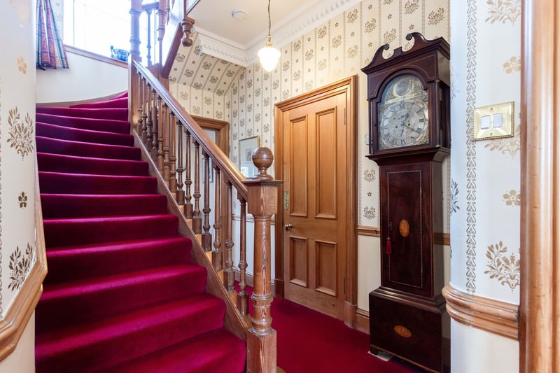 The welcoming entrance hall with a carpeted staircase to the upper floors.
