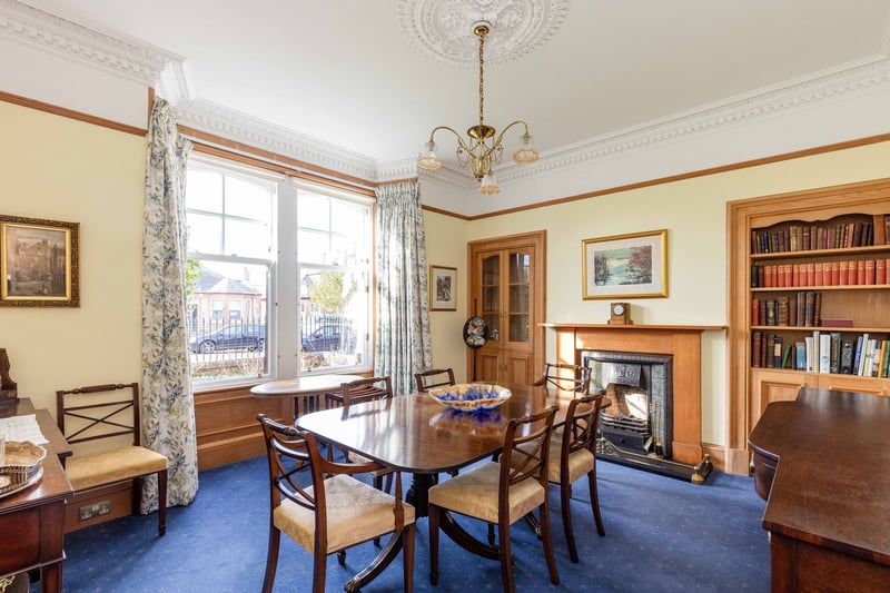 The large dining room / double bedroom with windows to the front.
The room includes a shelved wall press, a feature fireplace, picture rail and great period features.