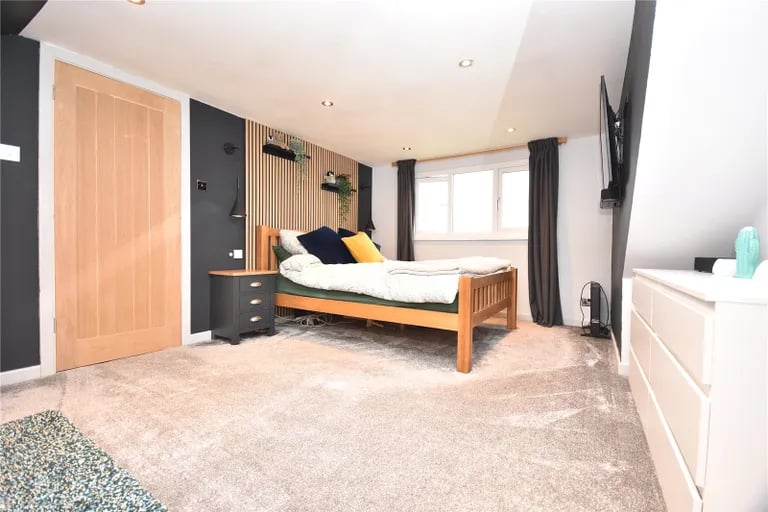 The stylish second bedroom features ceiling spotlights and overlooks the rear.
