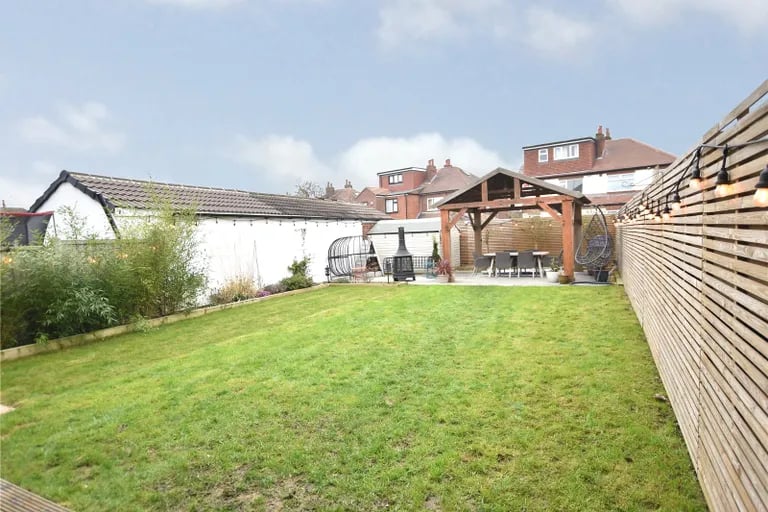 To the rear is a lovely landscaped garden with large lawn.