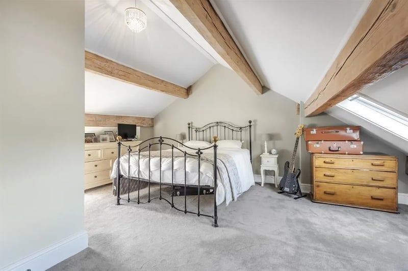 The top floor hosts this gorgeous double bedroom with exposed ceiling beams and skylight windows.