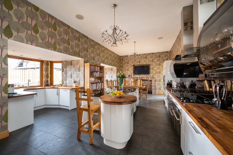 More recently, an open-plan contemporary dining-kitchen has been fitted, featuring a large island with in-set sink, and double doors to the outside.