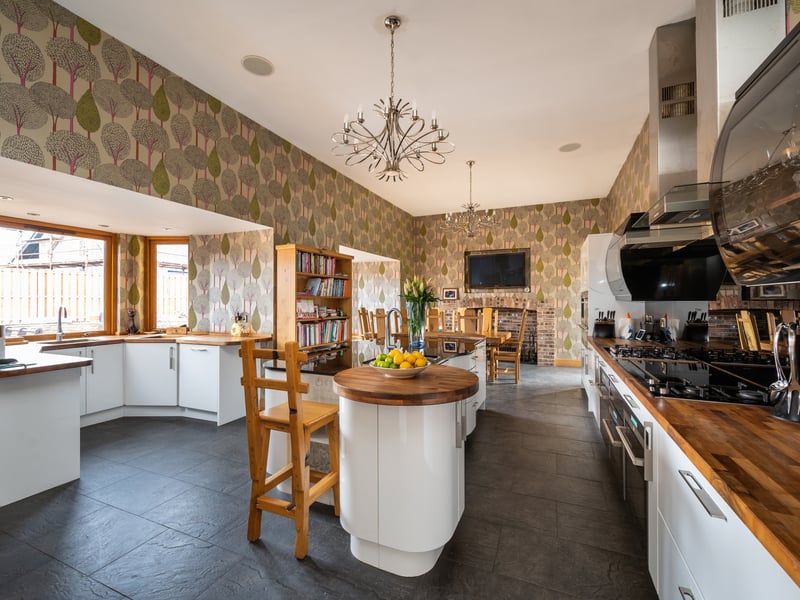 More recently, an open-plan contemporary dining-kitchen has been fitted, featuring a large island with in-set sink, and double doors to the outside.