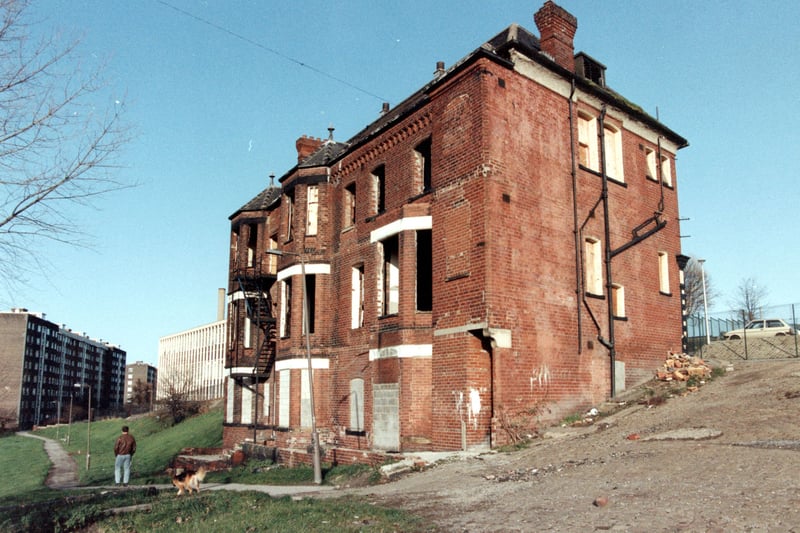 A rear view of Old Bank Club, now demolished, used to stand on top of Cavalier Hill. Mount St Mary's High School can be seen in the background. A man with his dog are walking across the field.
