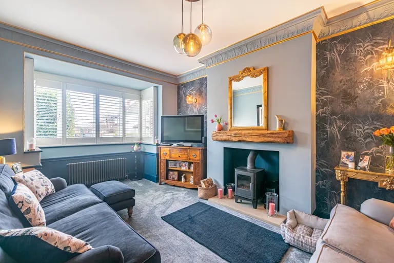 The lounge features a log burner and large window overlooking the front elevation.