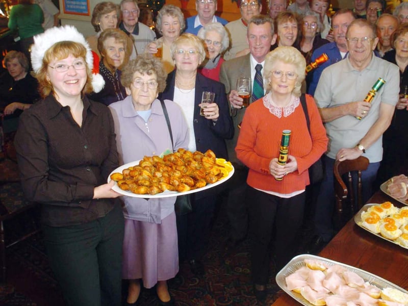 Landlady of The Woodcock, Danielle Jamieson, pictured with guests when the Whitehall Road watering hole served up a free festive lunch for pensioners in December 2004.