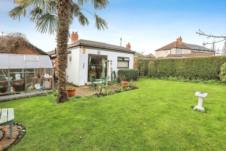 The generous private rear garden is mainly laid to lawn with high hedge borders and a greenhouse.