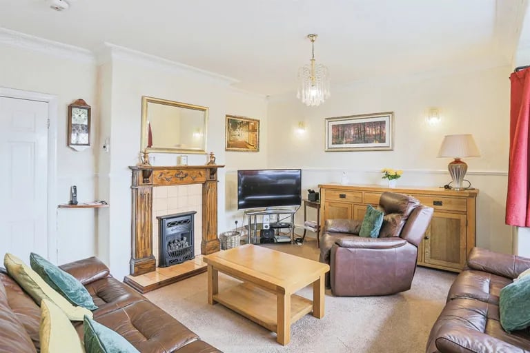 The spacious lounge with neutral décor features a gas fireplace with surround and a bay window to the front.