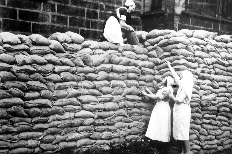 Sandbagging to prevent bomb damage to Morley Hall Maternity Home during the Second World War. Nursing staff from the Hall are helping to pile up sandbags.