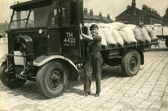Freda Bradshaw with her 2 tonne flat bed lorry. She collected goods from Accommodation Road goods station for delivery to Leeds markets, and completed all the work as a solo operation.
