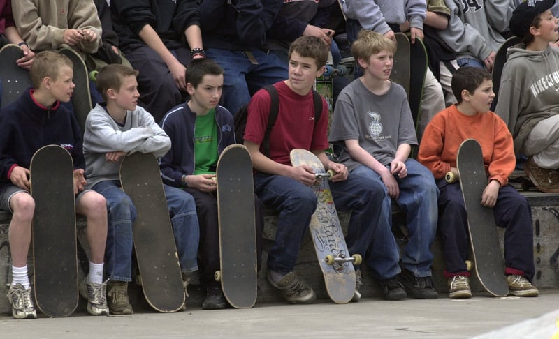 Young skateboarders sit on the wall at Devonshire Green during an event